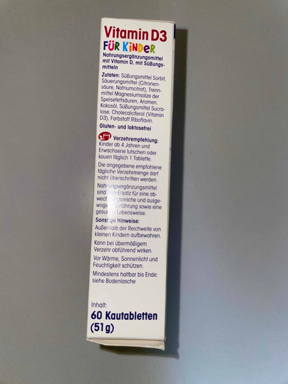 Seitenansicht einer Packung der Vitamine für Kinder im Test auf einer grauen Fläche.
