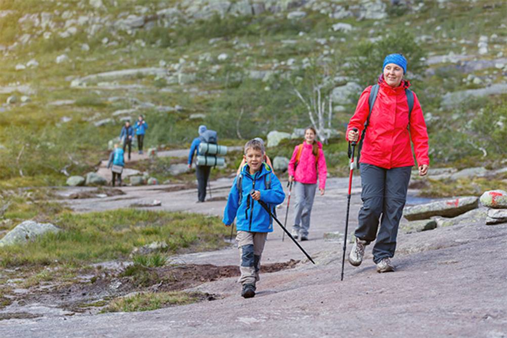 Kinder-Wanderstöcke im Test: Ein Junge mit seiner Mutter beim Wandern mit Wanderstöcken.