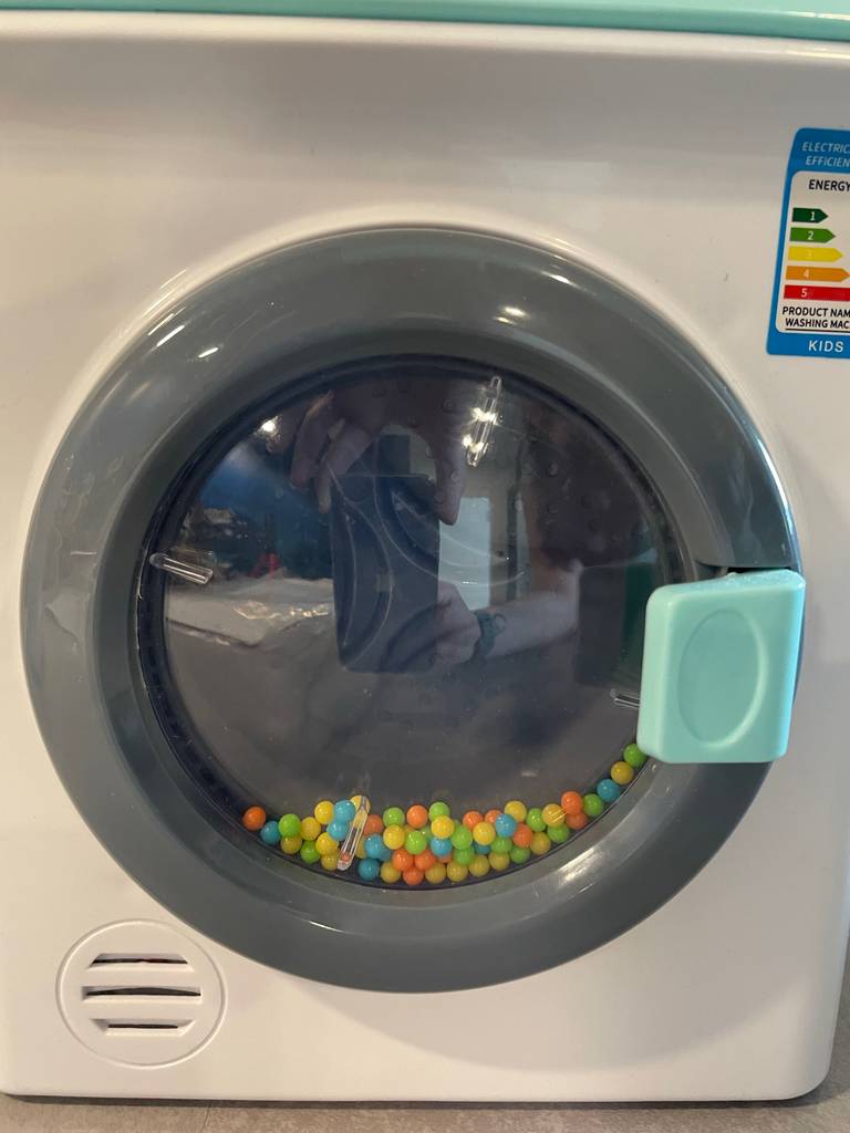 Kinder-Waschmaschine getestet: Nahaufnahme der Klappe mit bunten Kügelchen.
