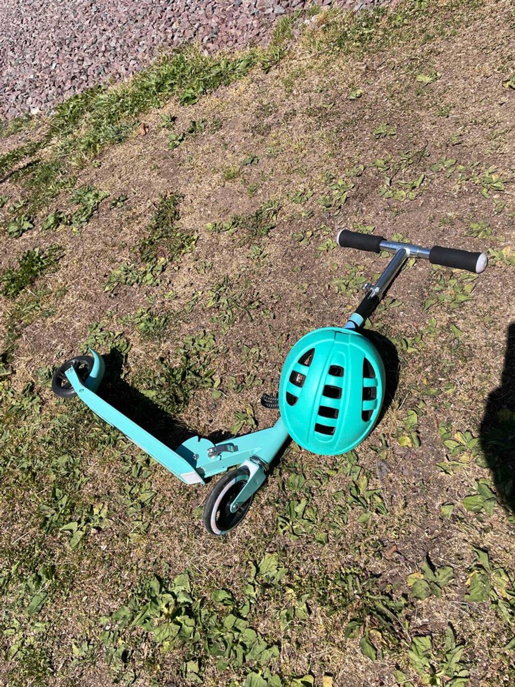 Auf dem Boden liegt ein getesteter Kinderfahrradhelm auf einem Roller. 