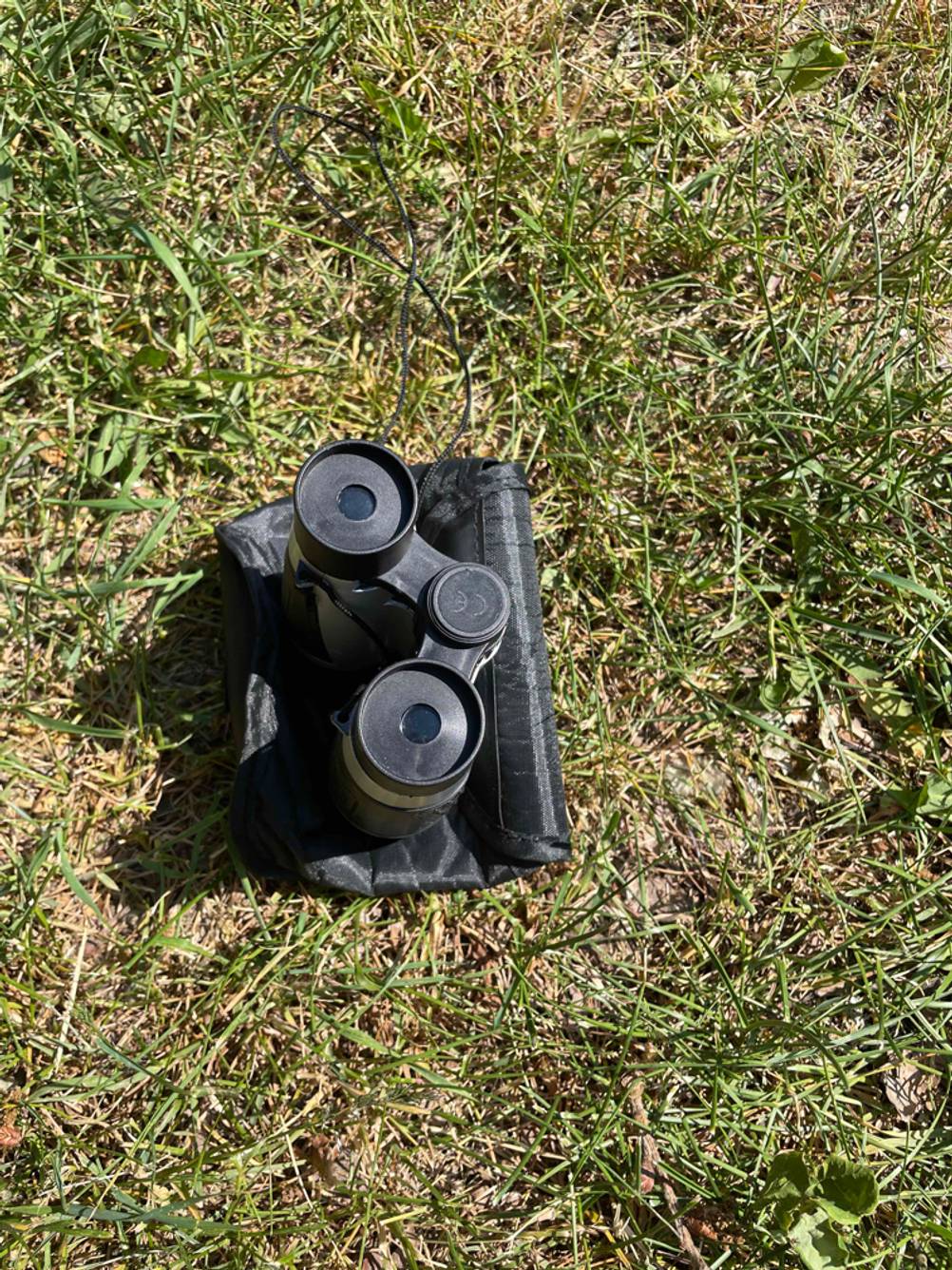 Kinderfernglas getestet: Ein Gerät steht auf einer schwarzen Tasche im Gras.