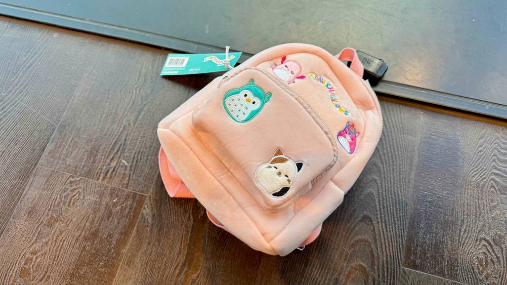 Auf eine Holzboden liegt ein Kindergartenrucksack Mädchen im Test.