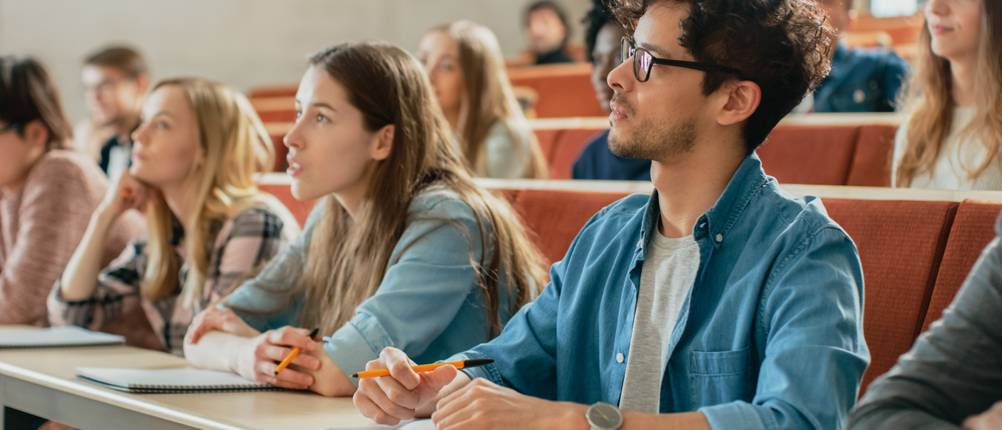 Mehrere Studenten sitzen im Hörsaal.