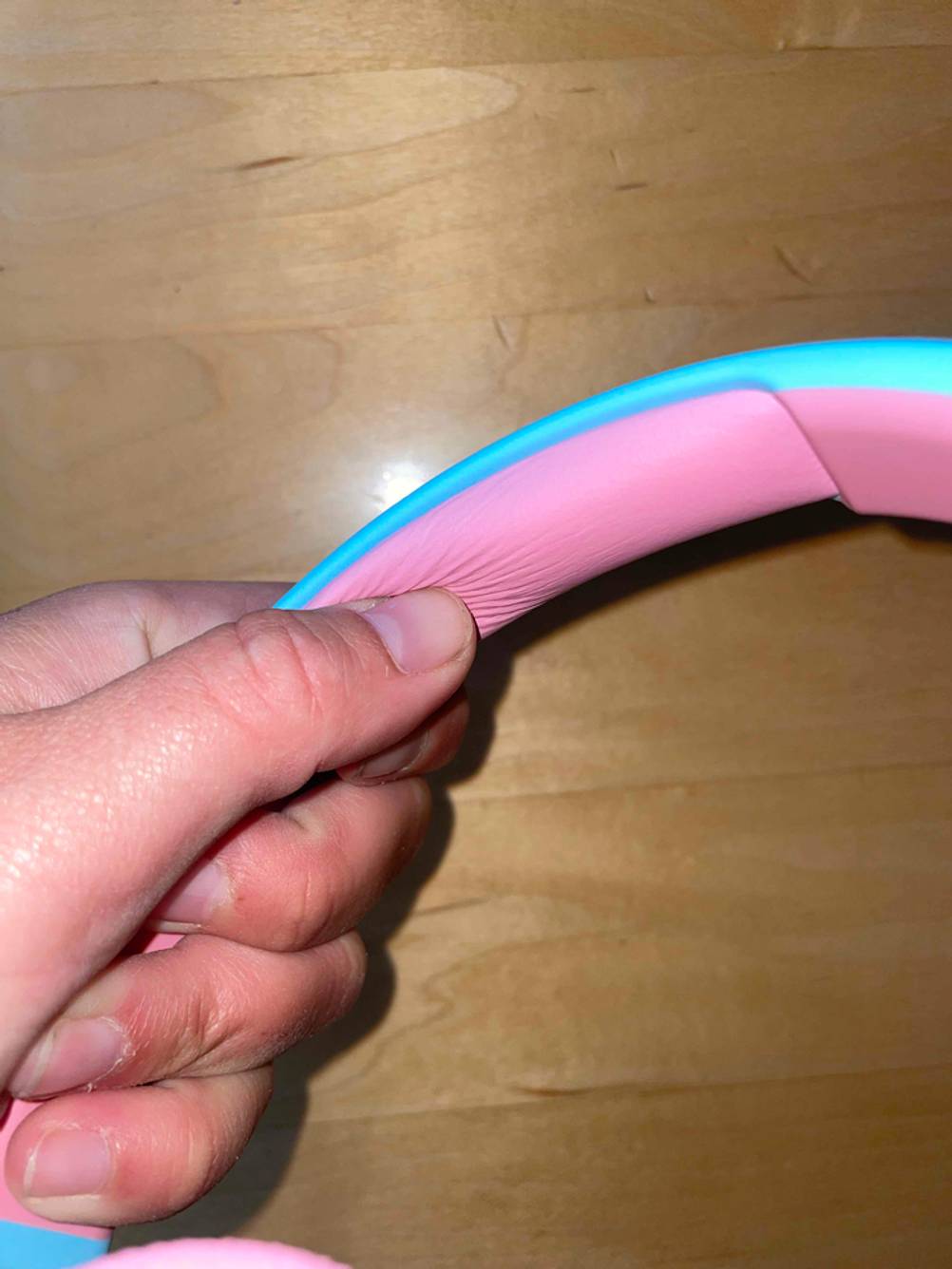 Eine Hand hält ein Paar getestete Kinderkopfhörer.