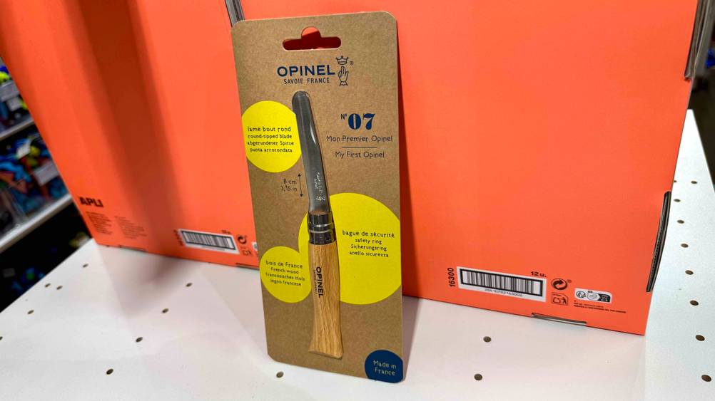 Das getestete Kindermesser lehnt an einem orangen Karton.