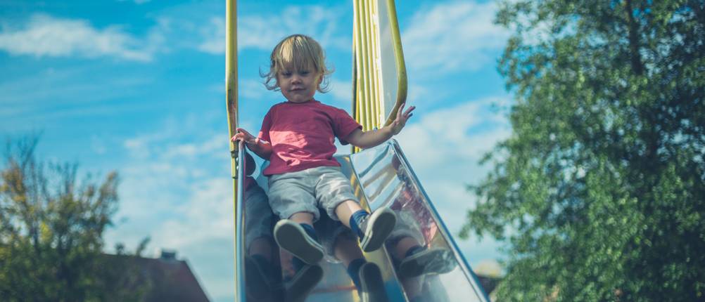 kleinkind auf kinderrutsche