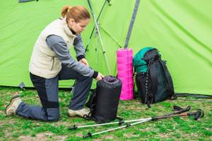 teenager packt schlafsack in beutel