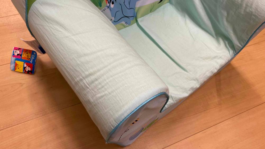 Im Test: Ein gerollter Kindersessel ist halb ausgerollt und liegt auf einem Boden.