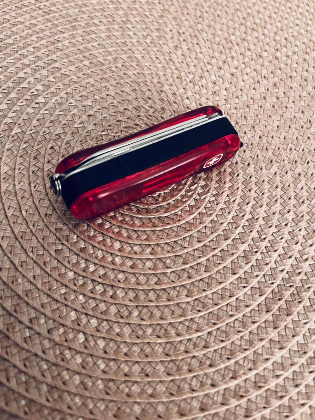 Ein getestetes Kindertaschenmesser in den Farben Rot-Schwarz befindet sich auf dem Boden. 