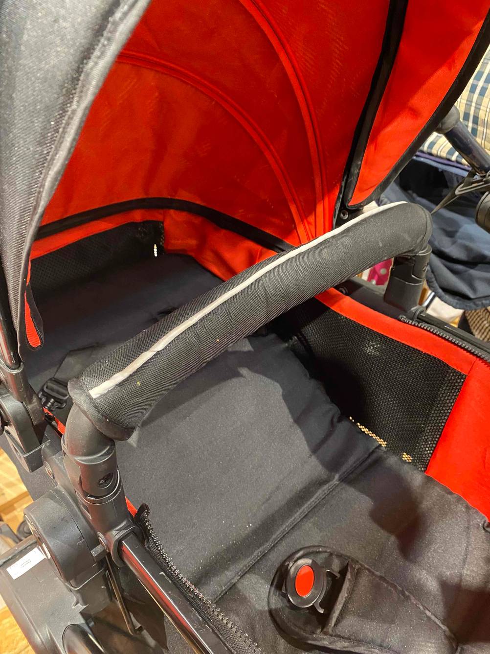 Auf dem Boden steht ein getesteter Kinderwagen mit schwenkbaren Rädern. 