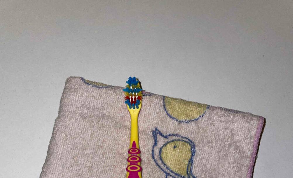 Nahaufnahme des Bürstenkopfes einer getesteten Kinderzahnbürste auf einem Handtuch.