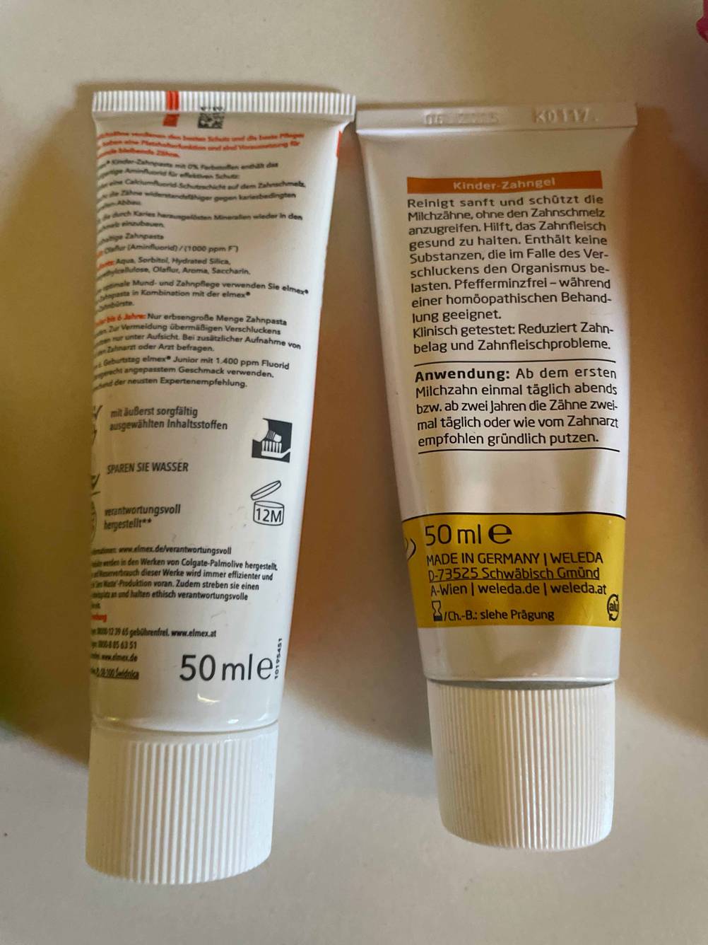 Die Rückseite von zwei getesteten Kinderzahnpasten mit Inhaltsstoffangaben. 