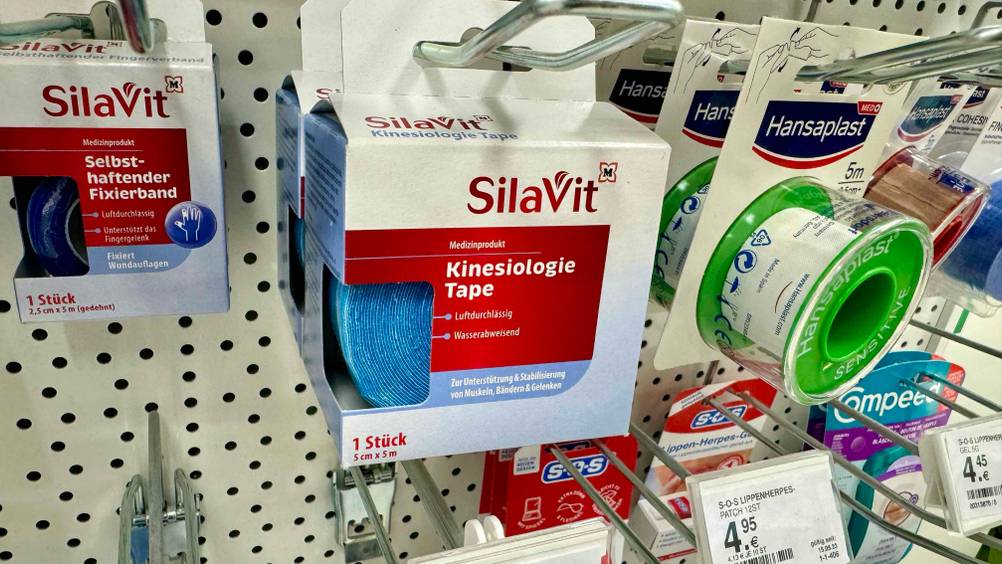 Getestet: Ein Kinesiologie-Tape in seiner Originalverpackung hängt neben anderen Produkten in einem Regal.