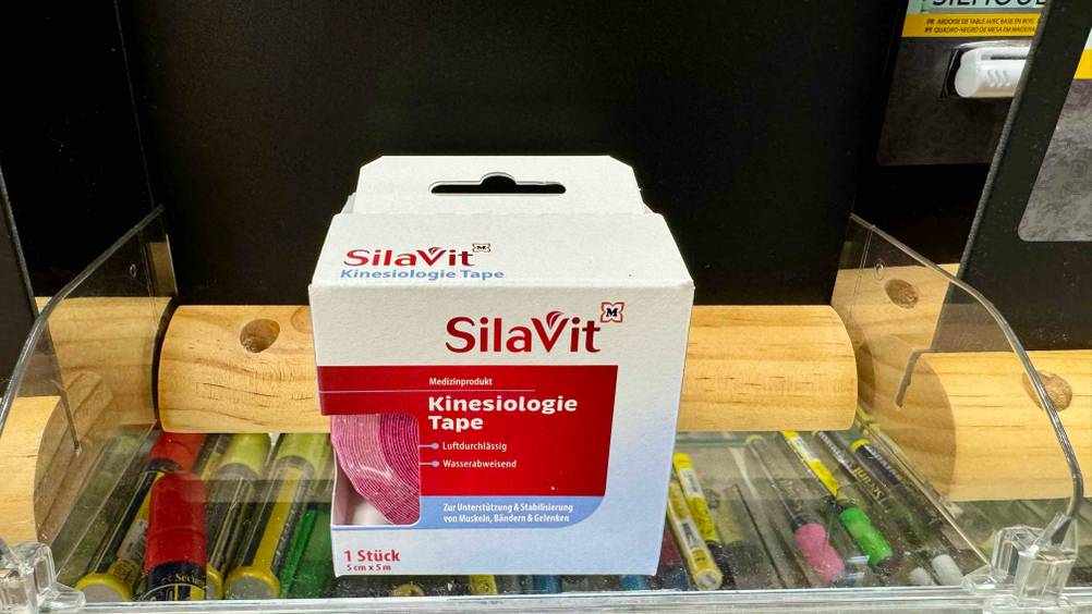 Ein getestetes Kinesiologie-Tape in der Originalverpackung von vorne in einem Verkaufsregal.