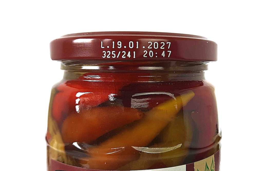 Auf dem Deckel eines Glases getestete eingelegte Peperoni steht das MHD.