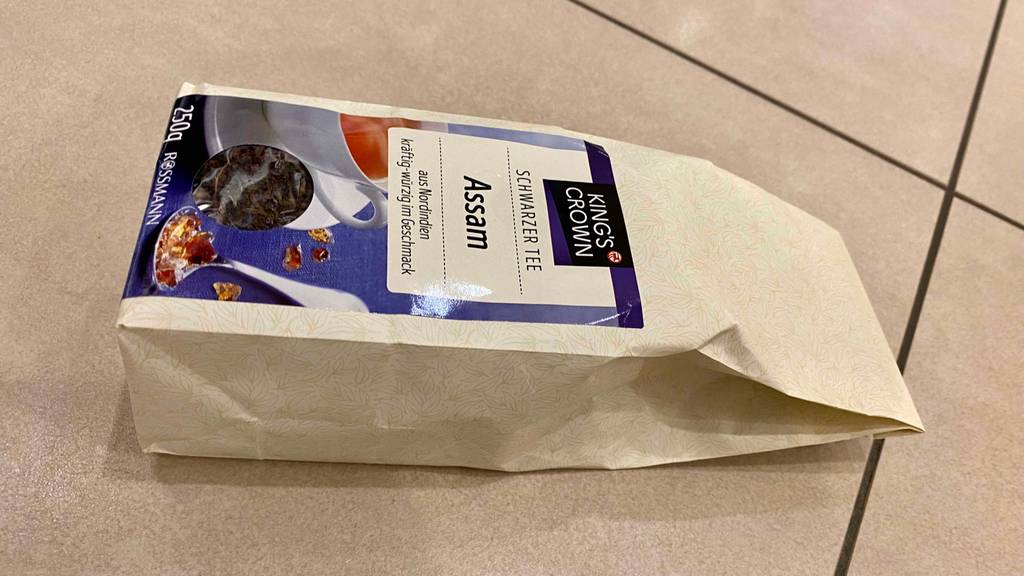Im Test: Packung Assam Tee von Kings Crown liegt quer auf hellem Hintergrund.