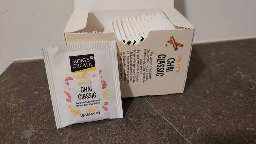 Im Test: Chai-Tee im Beutel neben seiner 20-Stück-Packung auf einer dunklen Oberfläche.