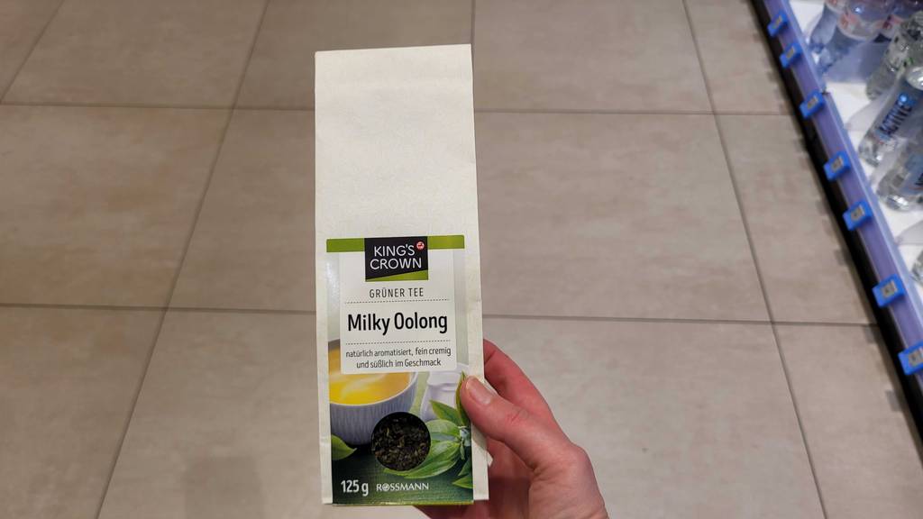 Getesteter Milky-Oolong-Tee befindet sich im 125-g-Beutel in einer Hand.