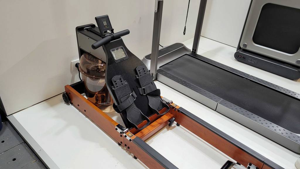 Im Test: Fußbereich eines Kingsmith Rudergeräts, das neben einem Laufband steht.