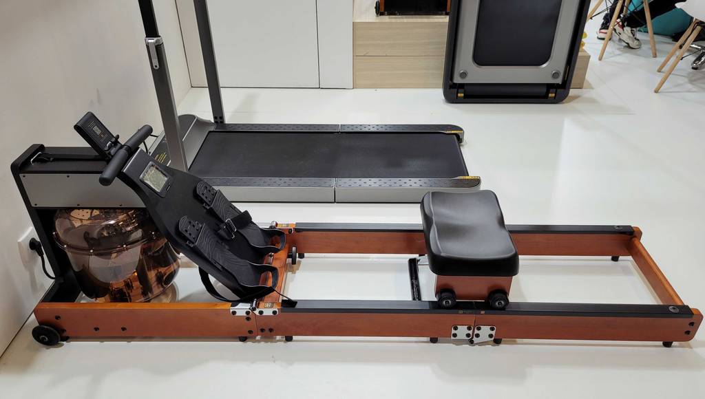 Im Test: Ein Kingsmith Rudergerät steht neben einem Laufband.