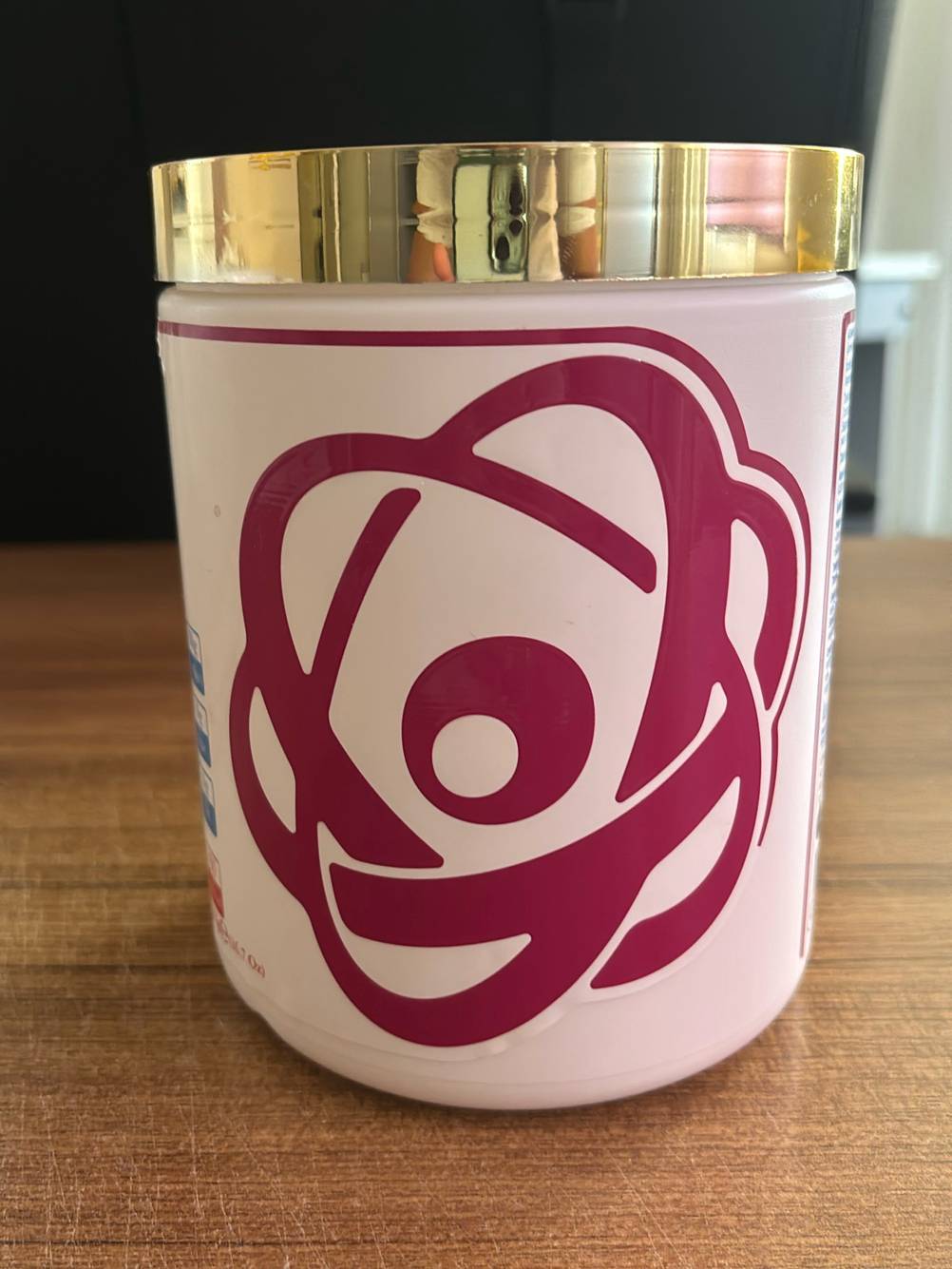 Nahaufnahme des weinroten Designs auf einer rosa Kunststoffdose mit Kollagen im Test.