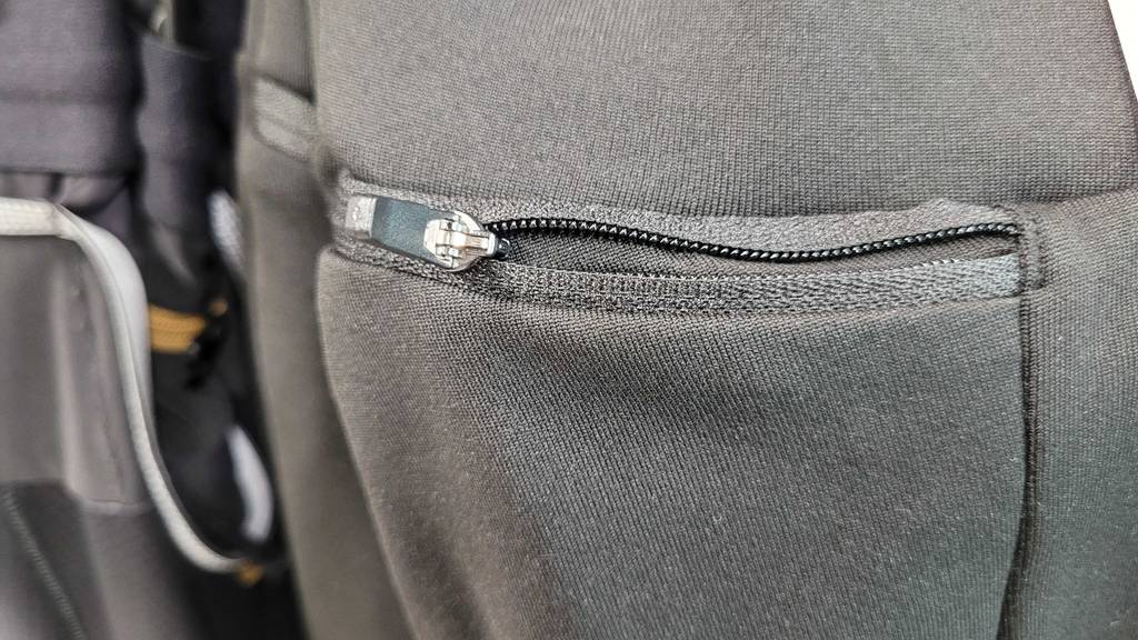 Thermo-Laufhose-Herren-Test: Die Detailansicht des Reißverschlusses einer Tasche, die in eine graue Thermo-Laufhose für Herren im Test integriert ist.