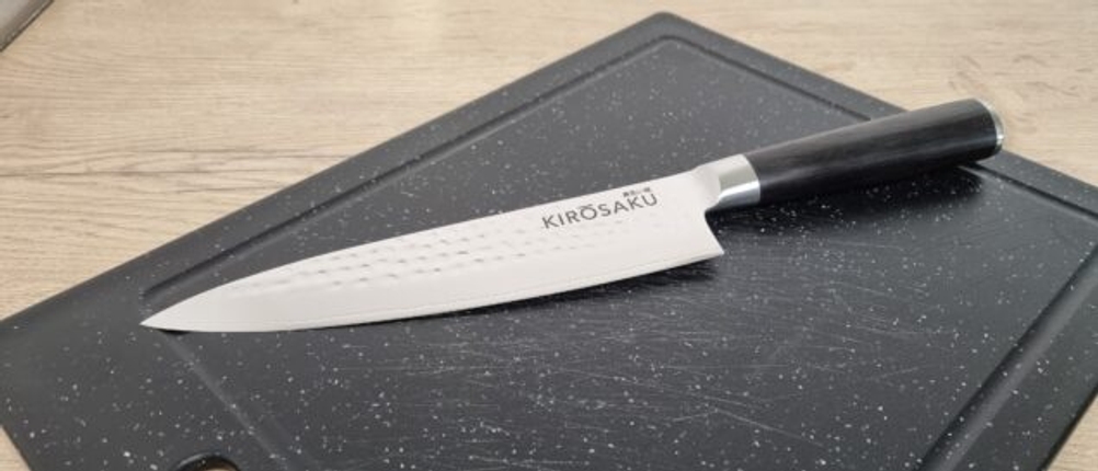 Ein Damastmesser auf einem Brett liegend.