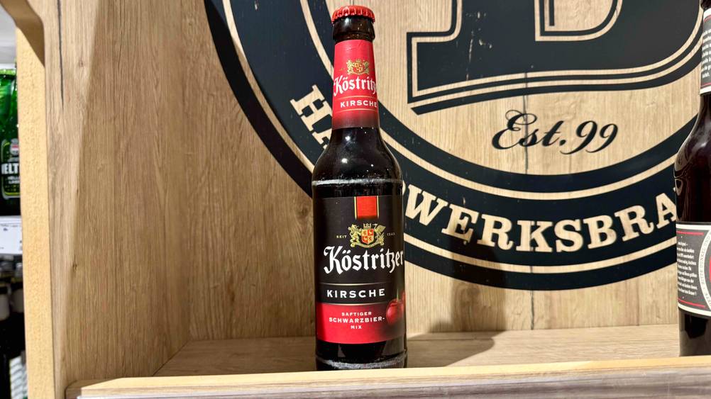 Kirschbier im Test: Eine Flasche von vorne in einer Holzbox.
