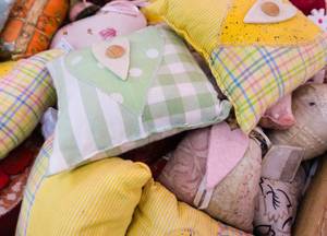 Baby-Kirschkernkissen im Test: Karierte bunte Kirschkernkissen auf einem Haufen