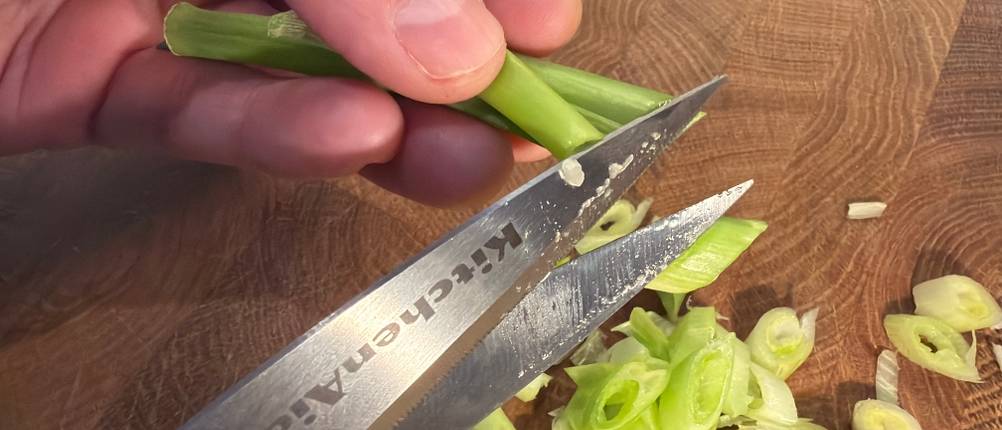 Frühlingszwiebeln werden mit der Kitchenaid-Allzweck-Küchenschere geschnitten