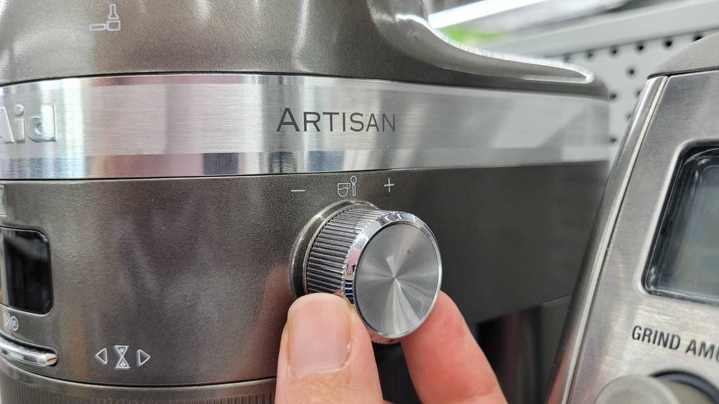 Elektrische Kaffeemühle getestet: Zwei Finger drehen an dem Rad zur Mahlgradeinstellung.