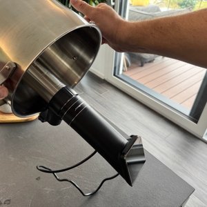 Eine Hand hält einen Kochtopf mit dem KitchenBoss G330 im 90 Grad Winkel