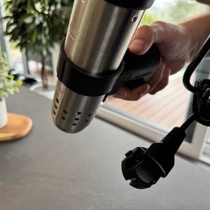 Eine Hand hält den KitchenBoss G330 an seiner Halterung fest