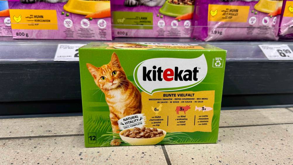 Vor einem Regal mit Preisangaben steht auf dem Boden eine Packung Kitekat-Katzenfutter im Test.