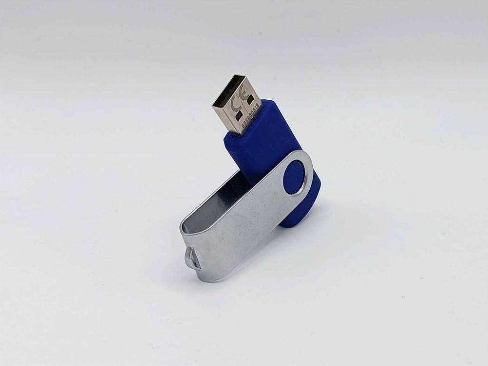 Ein getesteter USB-Stick mit geöffneter Klappe auf einer hellen Fläche.