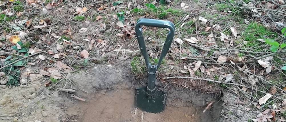 Klappspaten getestet: Ein Klappspaten mit D-Griff steckt in einem Erdloch.