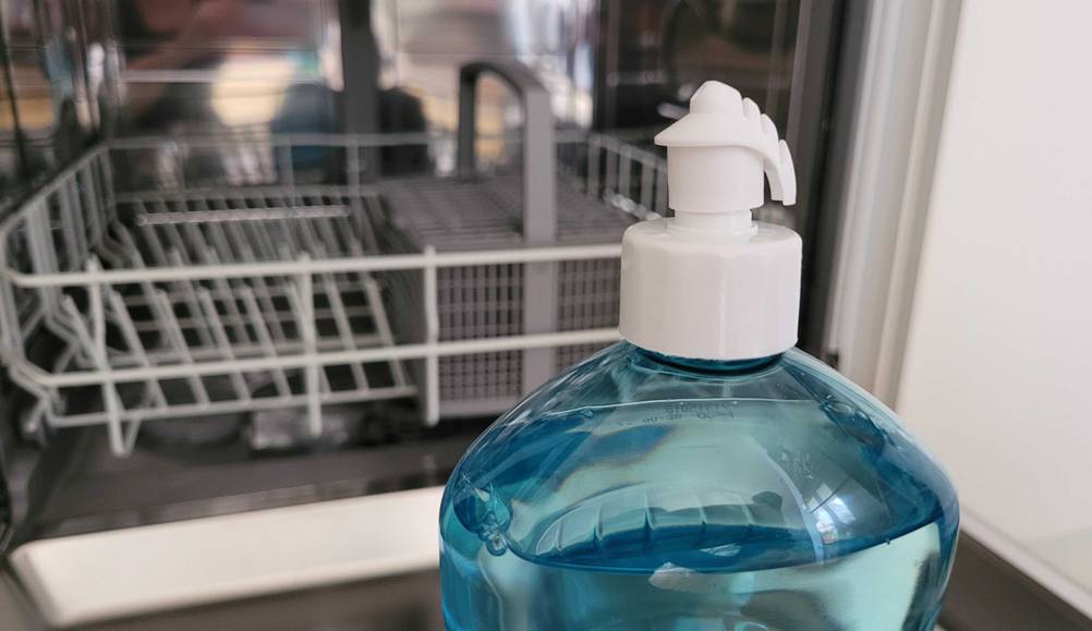Klarspüler getestet: Eine Flasche steht vor einer Spülmaschine.