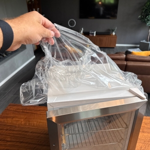 Eine Hand zieht eine Folie vom Klarstein Beersafe M ab.