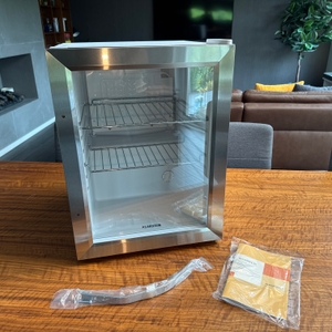 Der Klarstein Beersafe M steht neben seinem Griff und der Anleitung auf einem Tisch.