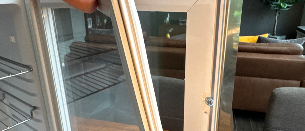 Das Silikon im Rahmen der Tür des Klarstein Beersafe M wird von einer Hand abgelöst.