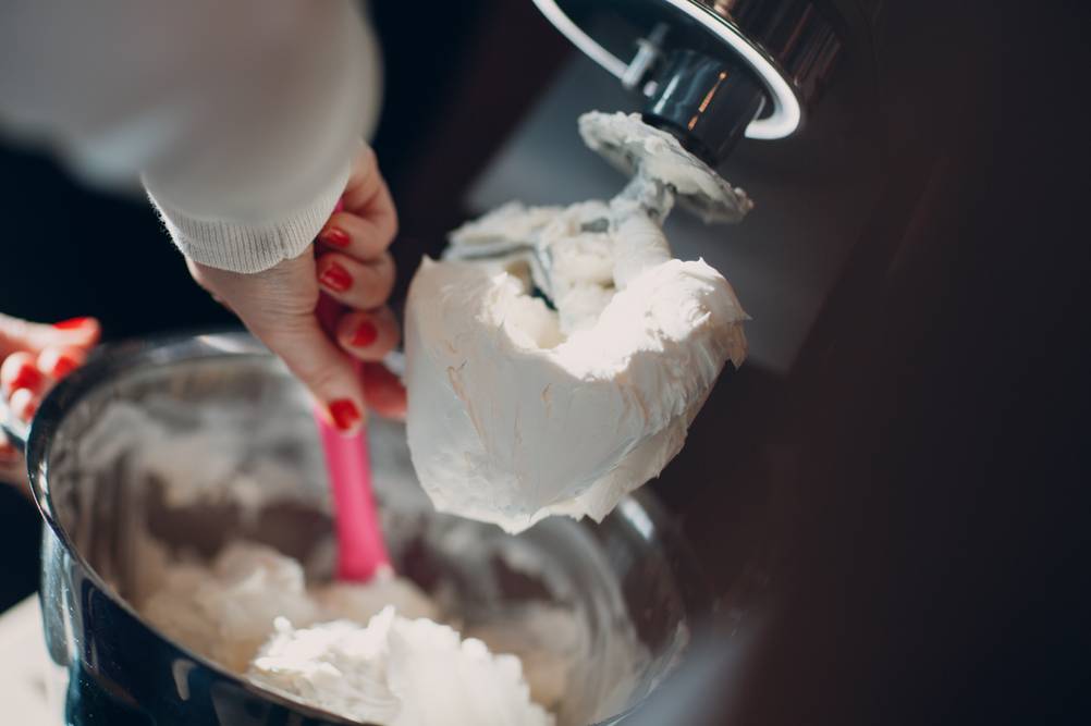Klarstein-Eismaschine-Test: Eine Frau rührt mit einem Löffel Eis aus einer Eismaschine. 