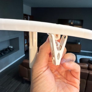 Eine Hand hängt eine Klammer an die Klarstein ShirtButler Deluxe