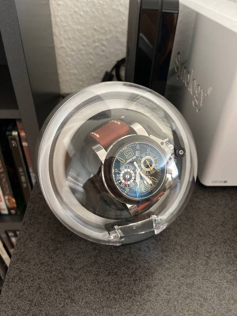 Uhrenbeweger-Test: Nahaufnahme eines runden Modells mit transparentem Deckel, im Inneren eine Uhr.