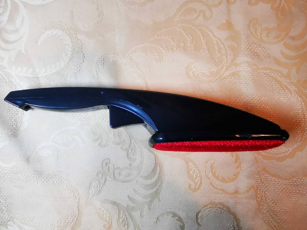 Die getestete Kleiderbürste auf der Seite liegend von oben auf einer Tischdecke.