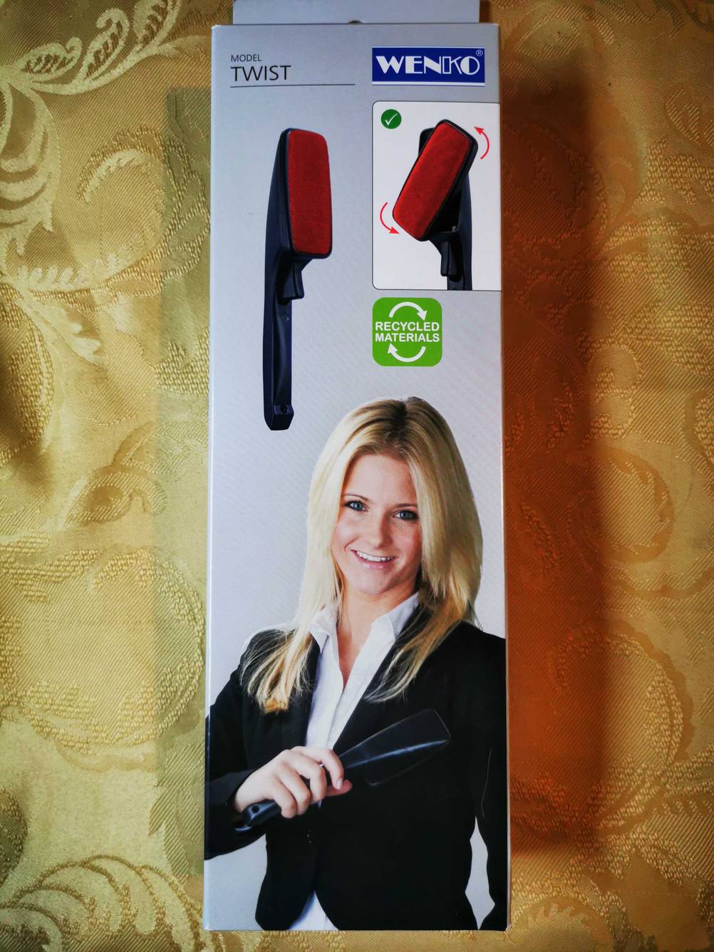 Die Originalverpackung der getesteten Kleiderbürste auf einer gelben Tischdecke.