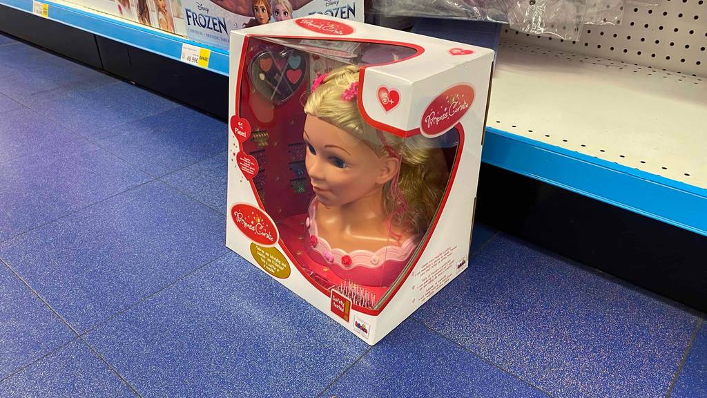 Getestet: Schminkpuppe-Puppenkopf Princess Coralie steht in der Verpackung mit Sichtfenster vor einem Verkaufsregal.