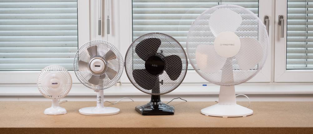 eine Aufreihung von vier unterschiedlich großen Ventilatoren auf einem Kork-Tisch