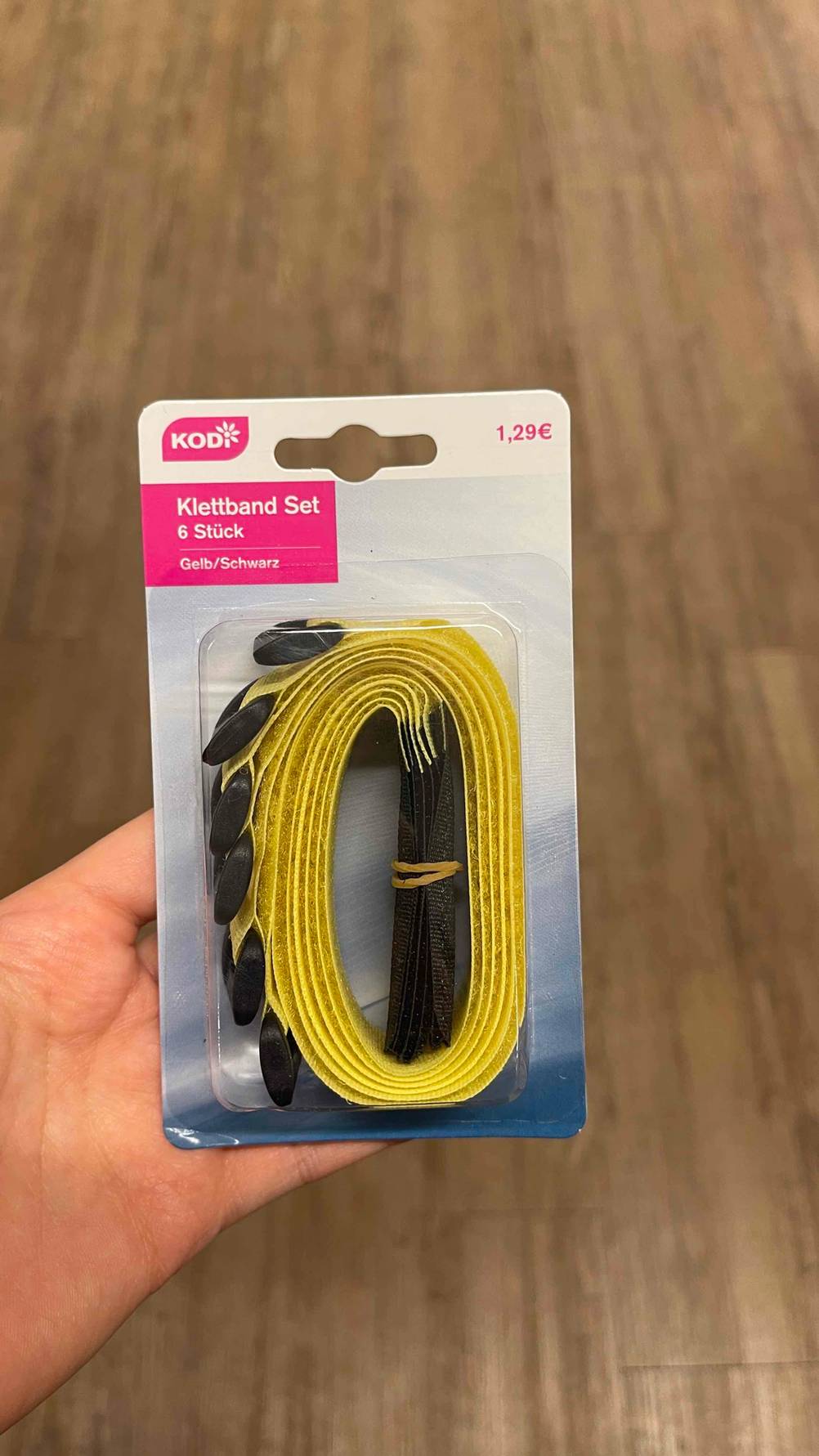 Klettband im Test: Eine Hand hält das verpackte Klettband hoch.