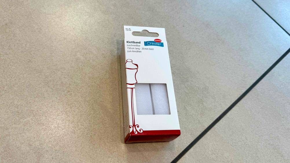 Eine Packung des getesteten Klettbandes auf einem Fließenboden liegend.