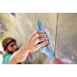 Klettergriffe-Test: Ein Mann greift nach einen blauen Klettergriff.